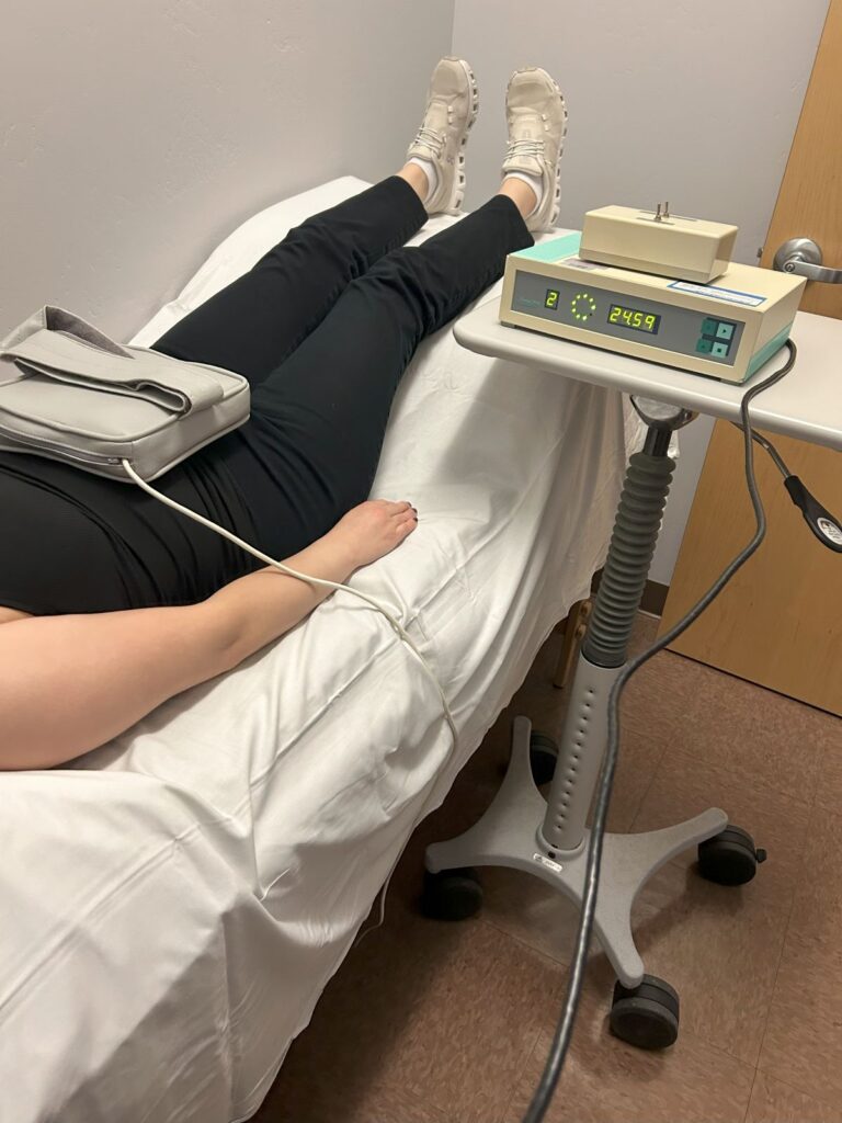woman lying on table with PEMF device on stomach