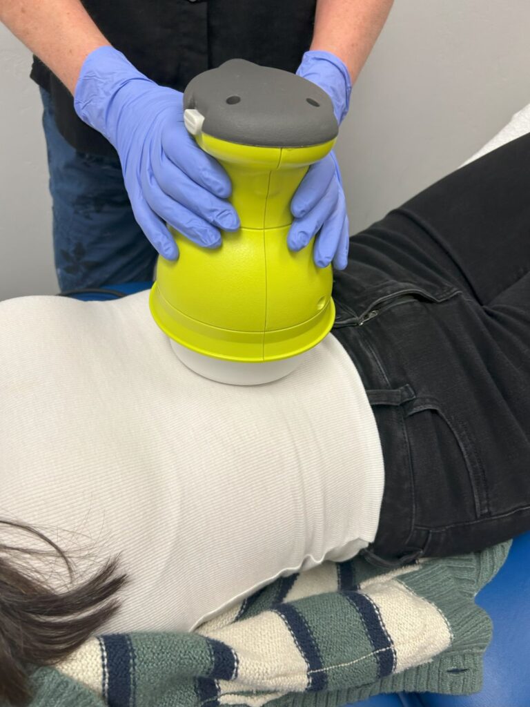 woman lying on table with PEMF device on stomach